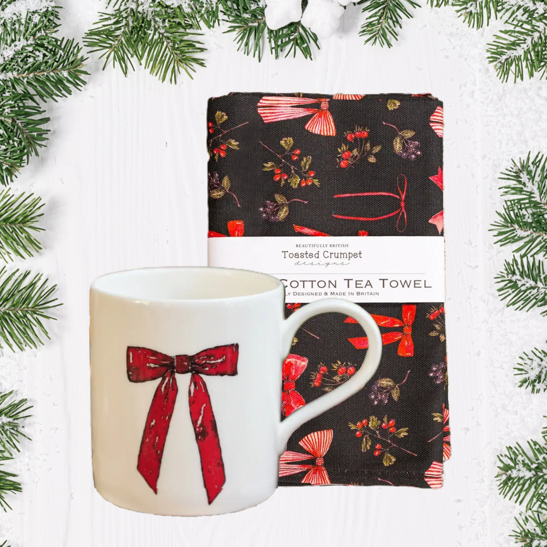 Mug and tea towel with with red bow festive design pattern on a white background