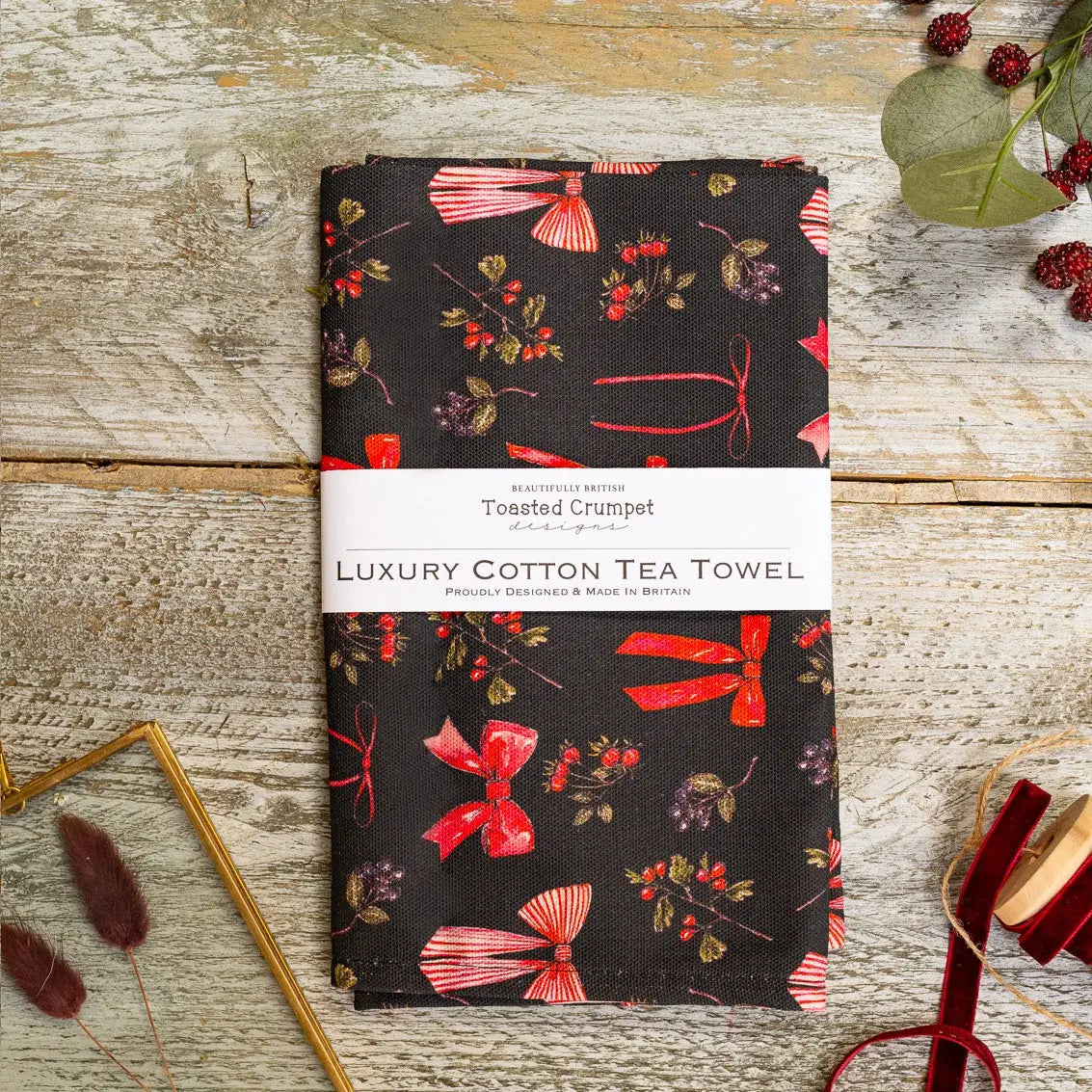 Tea Towel with red bows and red berries on black background.