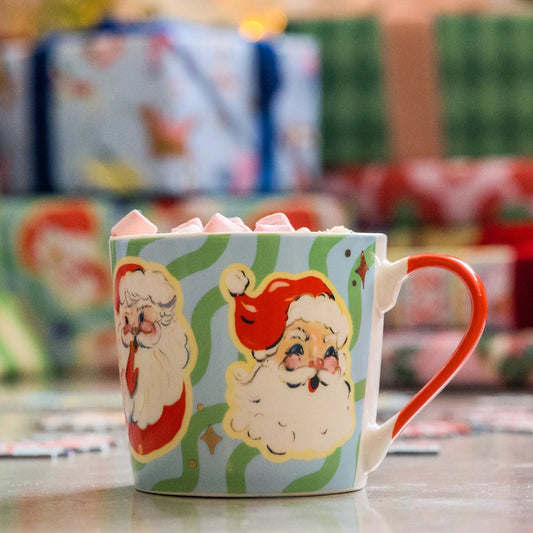 Christmas-themed mug with Santa Claus design on a blurred festive background