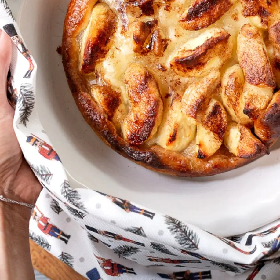 Person holding a pie with a decorative pattern on the edge of the dish