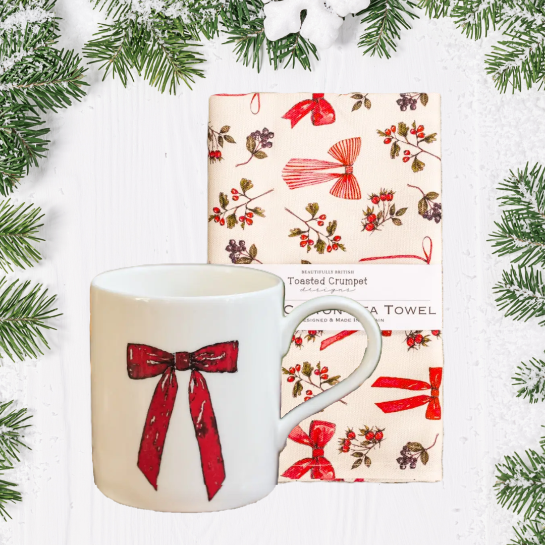 Mug and tea towel Christmas set with red bow design on a white background with greenery