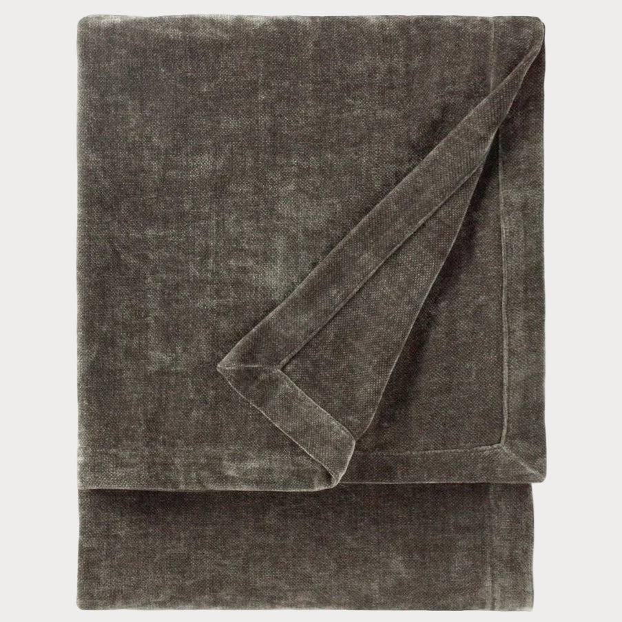 Folded grey throw blanket on a white background