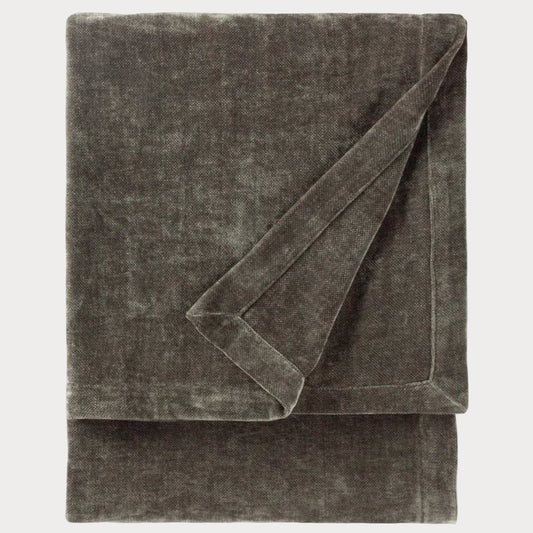 Folded grey throw blanket on a white background