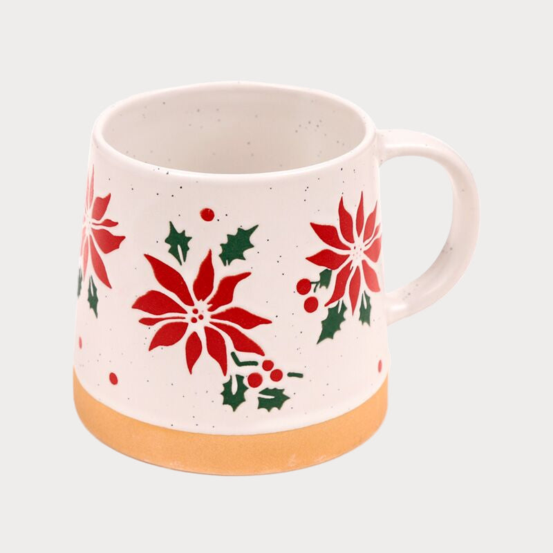 White mug with red poinsettia patterns on a white background