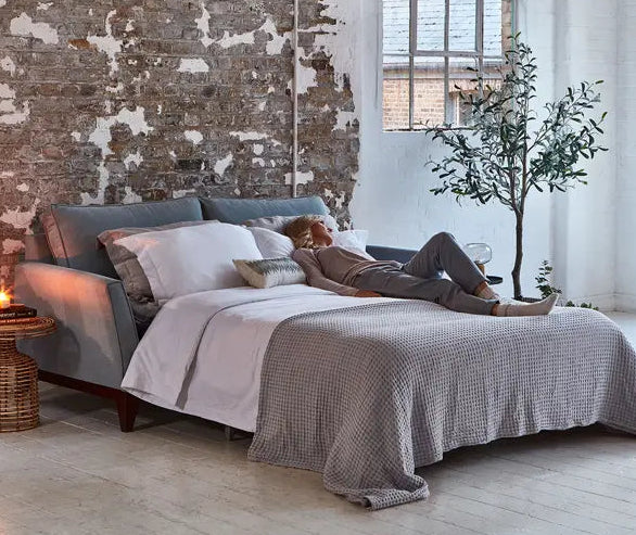 Modern sofa bed unfolded with bedlinen