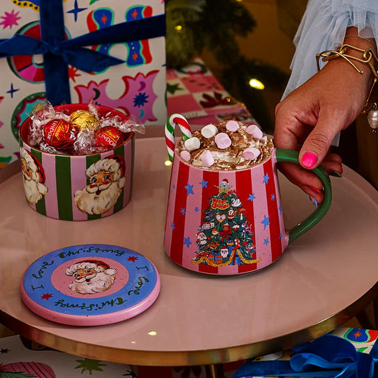 Decorative Christmas scene with colorful gifts and a mug on a small table.