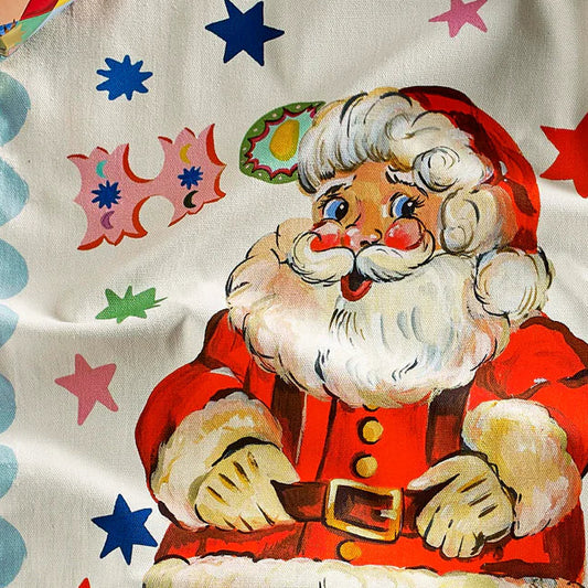 Decorative Santa Claus tea towel with colorful patterns on a pink background