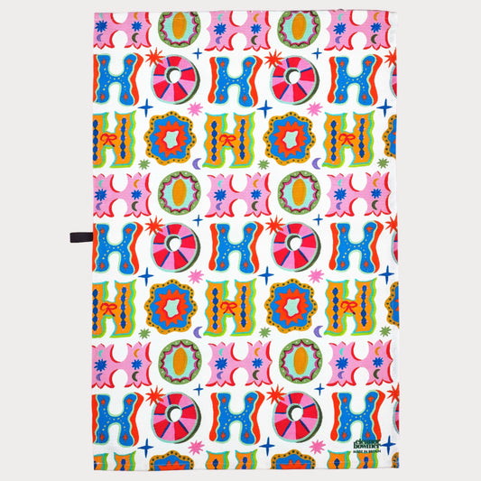 Colorful 'HO HO HO' patterned paper on a pink background